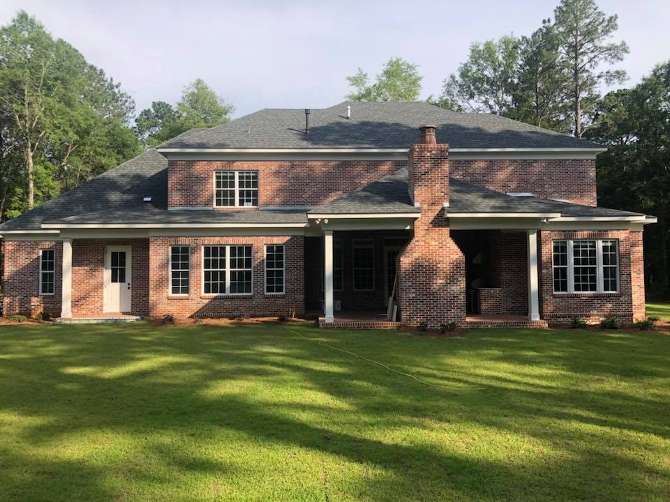 Rear exterior of two-story brick home with covered porch