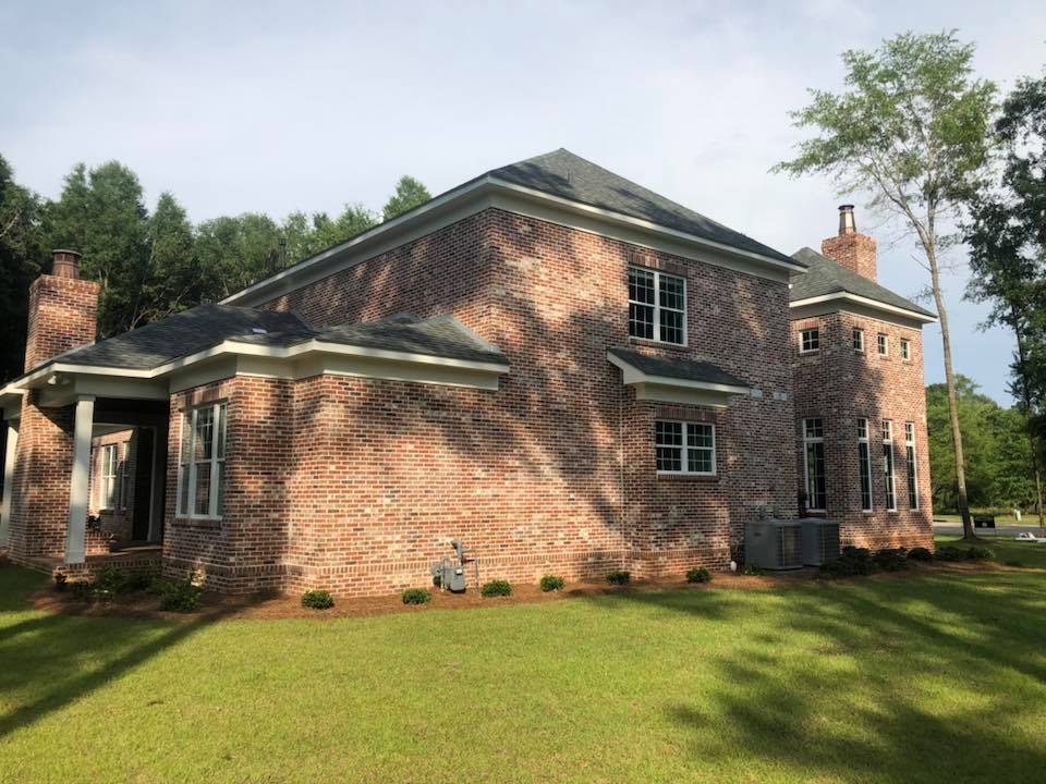 Side exterior of two-story brick home with chimney