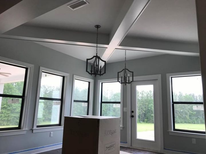 Vaulted tray ceiling with pendant lanterns and large windows in great room