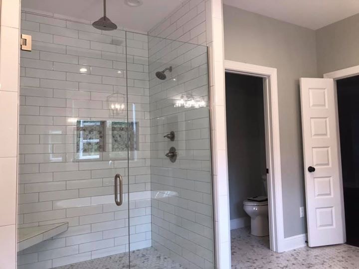 Subway tile glass shower enclosure with built-in niche and corner bench