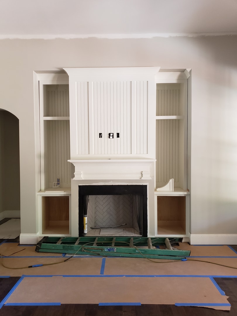Custom fireplace with white built-ins and herringbone firebox tile