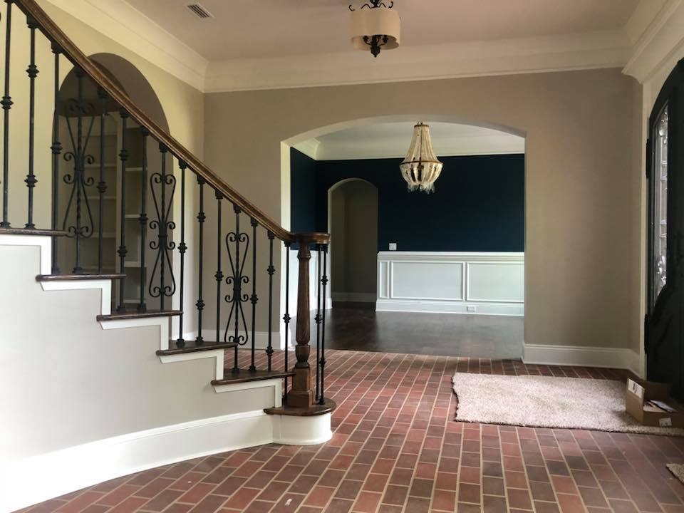 Grand foyer with wrought-iron staircase and arched doorways