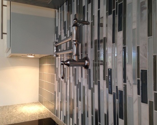 Stainless pot filler with vertical glass tile backsplash in gray, blue and white tones