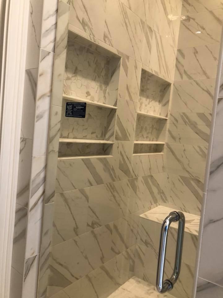 Custom marble tile shower with built-in shelving