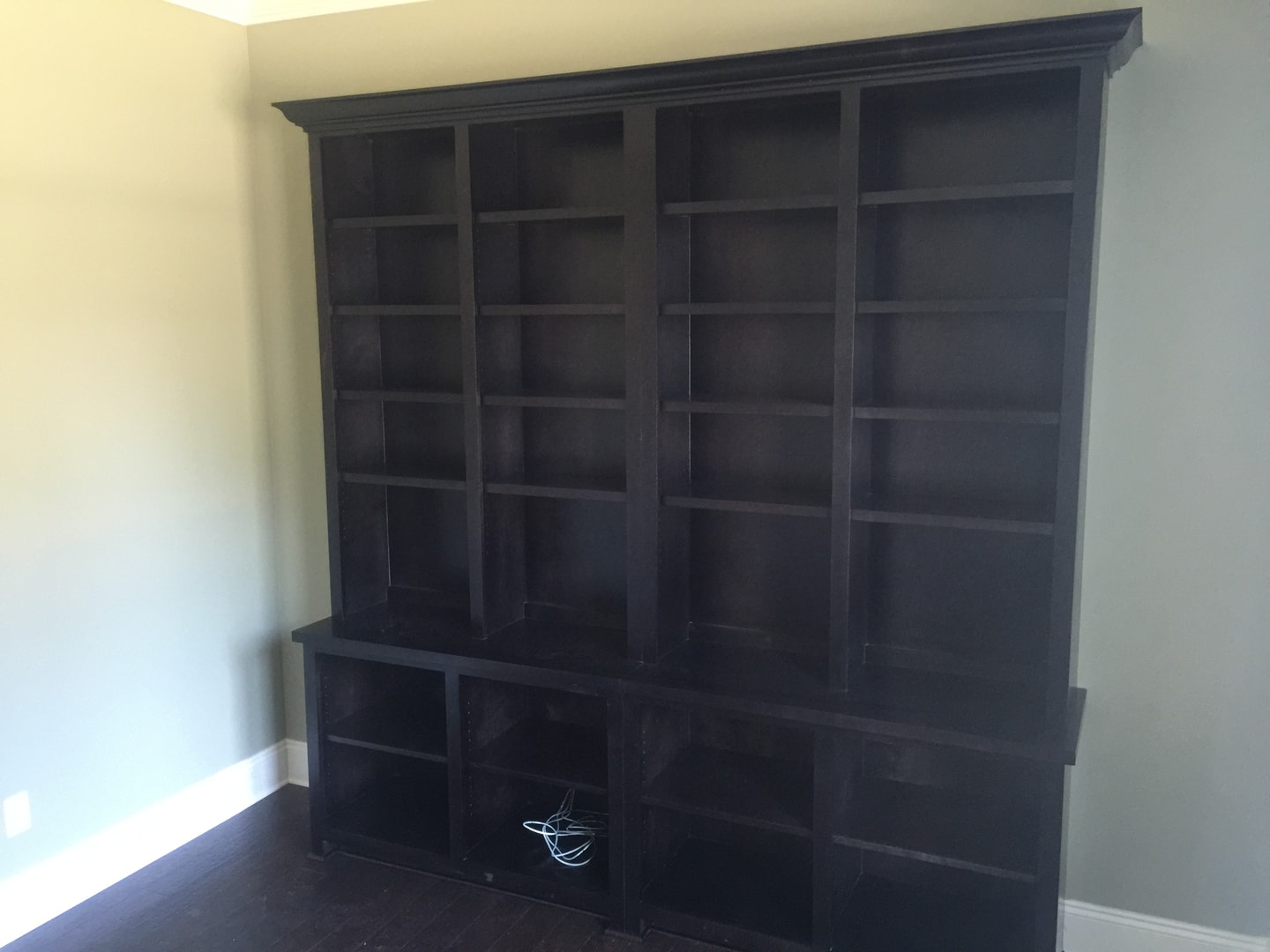 Floor-to-ceiling dark wood built-in bookcase with crown molding detail