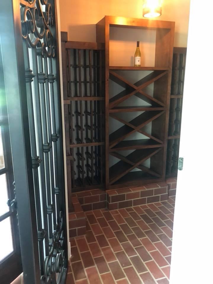Custom wine room with wood shelving and brick flooring